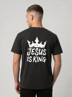 A man viewed from the back wearing a black t-shirt with a white graphic of a crown and the text 'JESUS IS KING'.