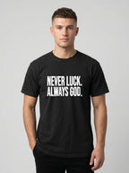 Person wearing a black T-shirt with white text reading “Never luck. Always God.”
